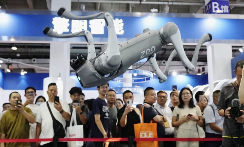 Crowds watch a robot perform a somersault at an exhibition in Beijing. Photo: Kyodo