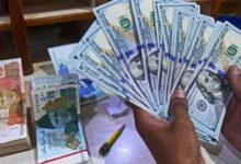 A foreign currency dealer counts US dollars at a shop in Karachi on May 19, 2022. — AFP/File