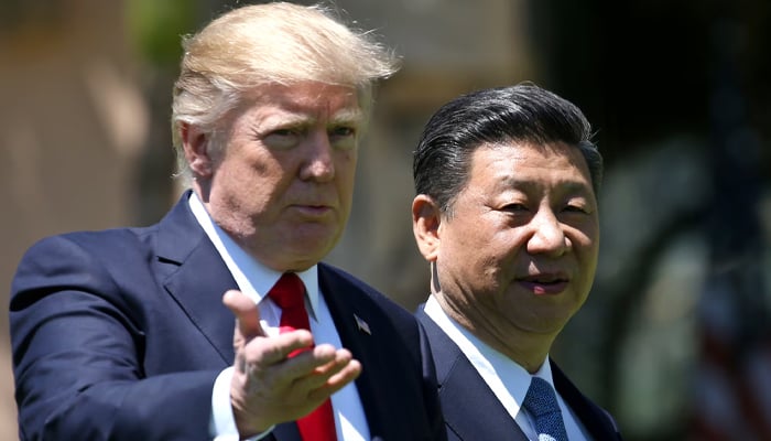 President Donald Trump (L) and Chinas President Xi Jinping chat as they walk along the front patio of the Mar-a-Lago estate after a bilateral meeting in Palm Beach, Florida. — Reuters