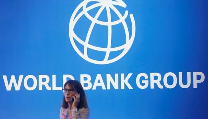 A participant stands near a logo of World Bank at the International Monetary Fund - World Bank Annual Meeting 2018 in Nusa Dua, Bali, Indonesia, October 12, 2018.— Reuters