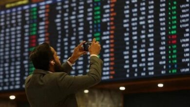 A man takes a photo of the electronic board at the Pakistan Stock Exchange, in Karachi November 28, 2023. — Reuters