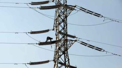 A technician works on porcelain insulators on power transmission tower in Karachi. — Reuters/File