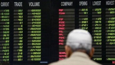 Pakistani traders stand beneath an electronic board displaying share prices at the Pakistani Stock Exchange (PSX). — INP/File
