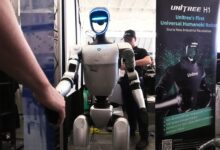 A Unitree robot shakes hands with a convention guest at the Robotics Summit & Expo, Wednesday, April 30, 2025, in Boston. (AP Photo/Charles Krupa)