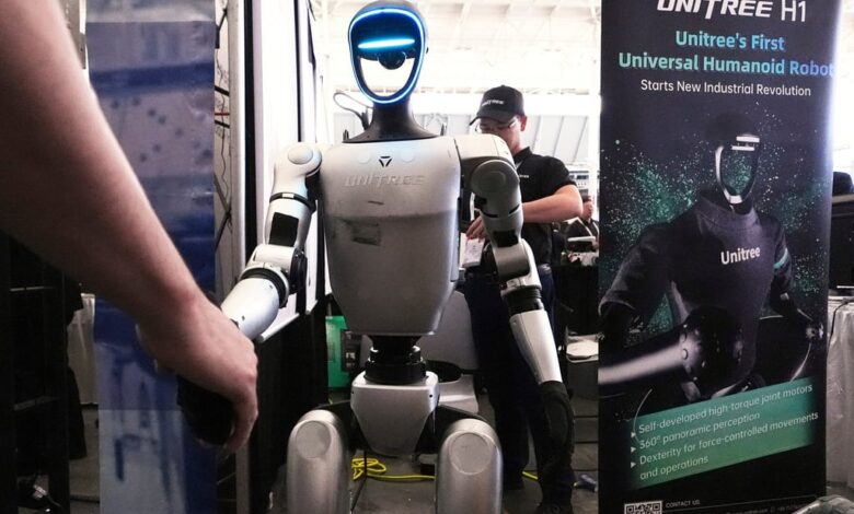 A Unitree robot shakes hands with a convention guest at the Robotics Summit & Expo, Wednesday, April 30, 2025, in Boston. (AP Photo/Charles Krupa)