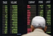 Pakistani traders stand beneath an electronic board displaying share prices at the Pakistani Stock Exchange (PSX). — INP/File